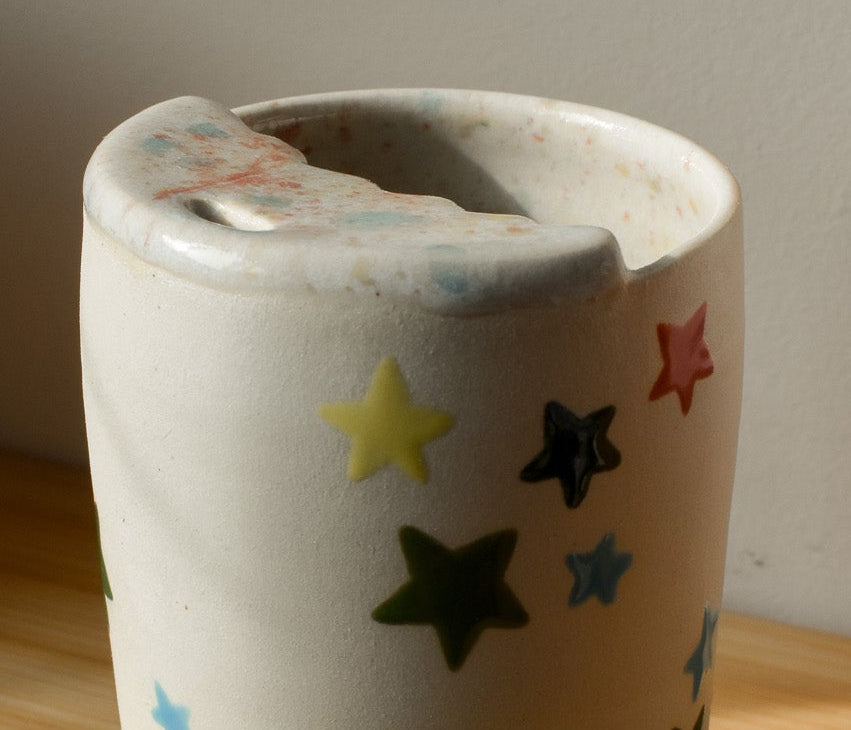 Ceramic cup with star patterns on a wooden surface