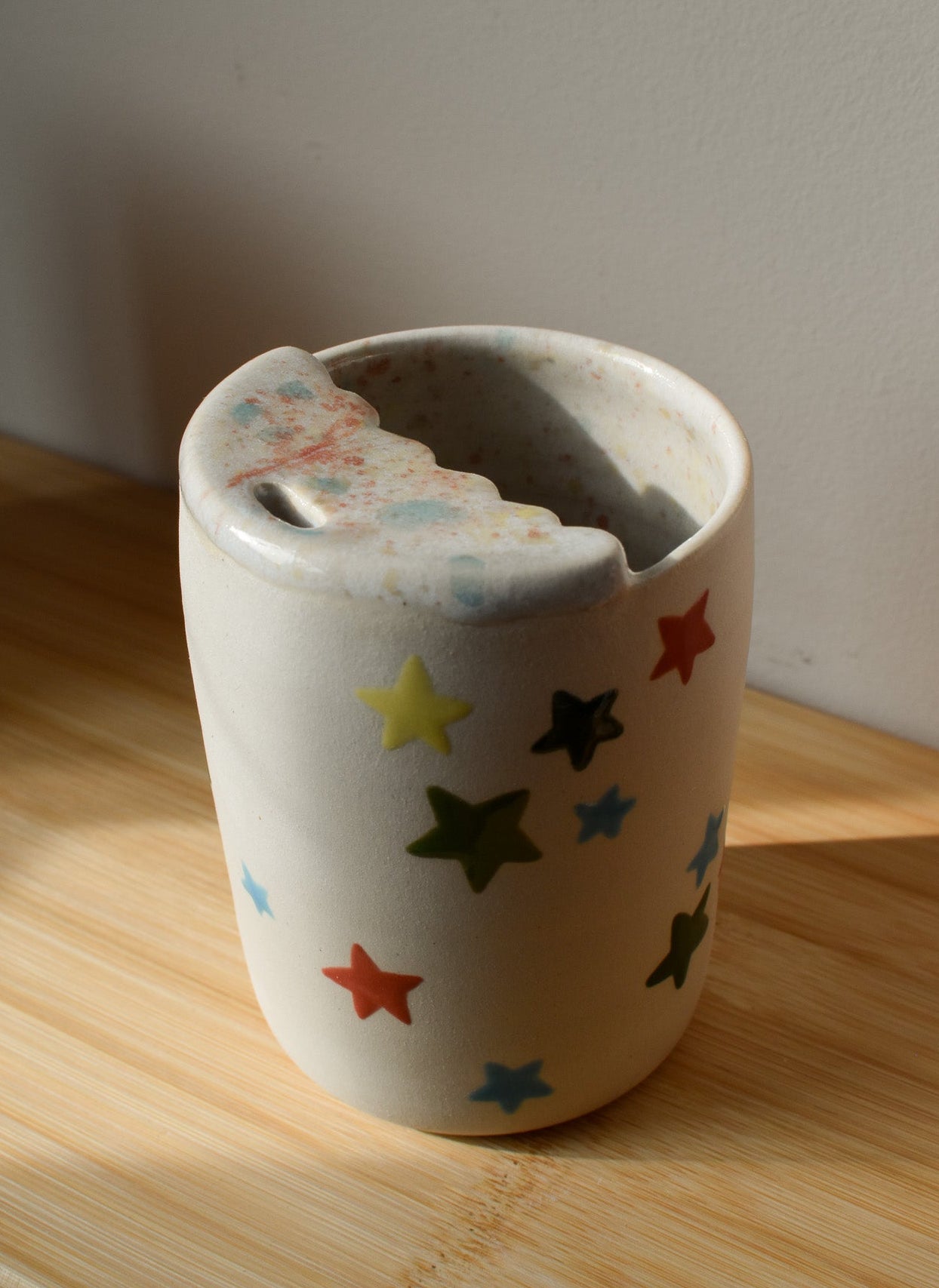 Ceramic cup with star patterns on a wooden surface